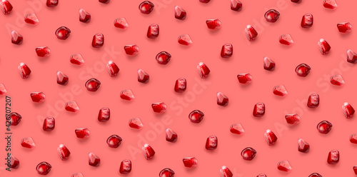 Fresh pomegrante seed pattern on pink background, from above