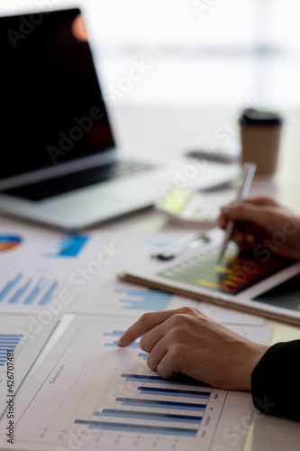 Close up of Businesswoman doing finances,accounting analysis,report,data and pointing graph at the office.