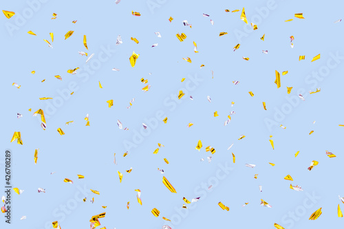 Golden silver sparkling confetti isolated on blue. Holiday effect