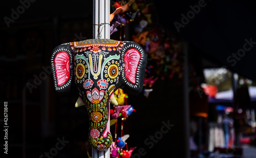 A colorful Lord Ganesha hand made mask for decoration with blur background on display at Hunar Haat fair. photo