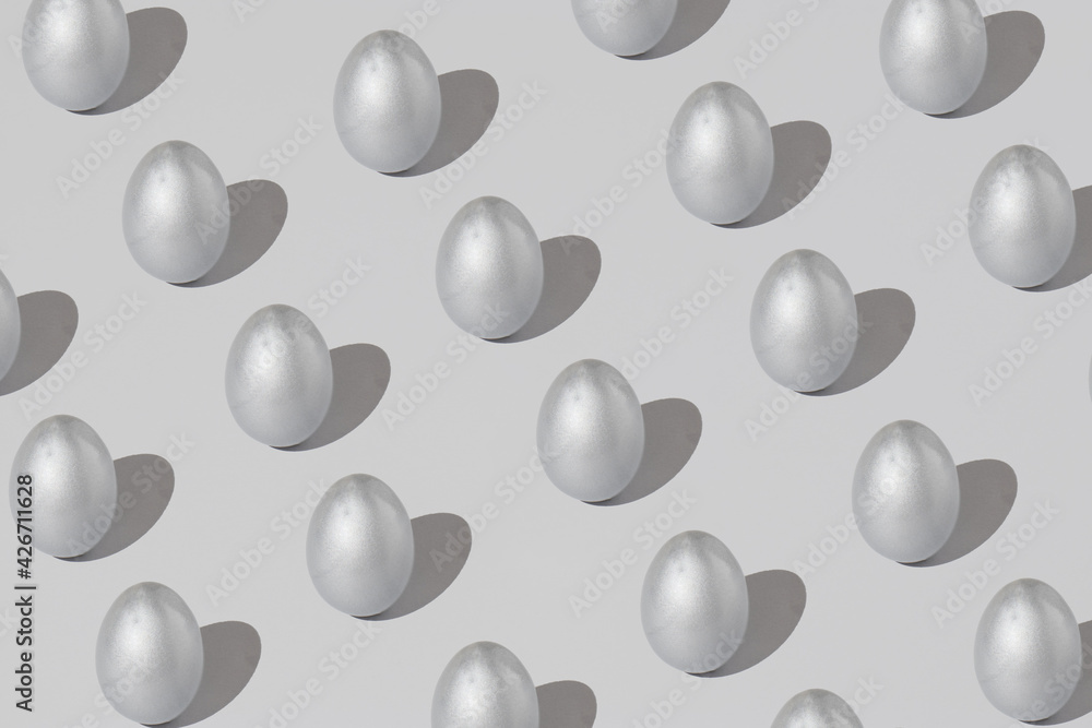 Pattern made of silver easter egg on a gray background. Minimal holiday concept.