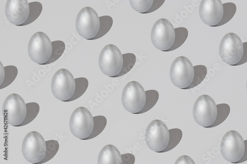 Pattern made of silver easter egg on a gray background. Minimal holiday concept.
