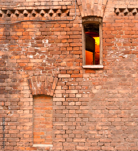 Two arched windows in brick wall