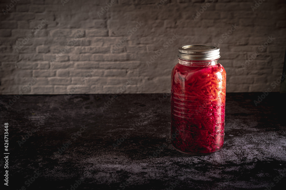 Dark moody food photography of a jar with homemade fermented red cabbage chucrut. Still life image with copy space. Dark moody food photography of a jar with homemade fermented red cabbage chucrut. Still life image with copy space.