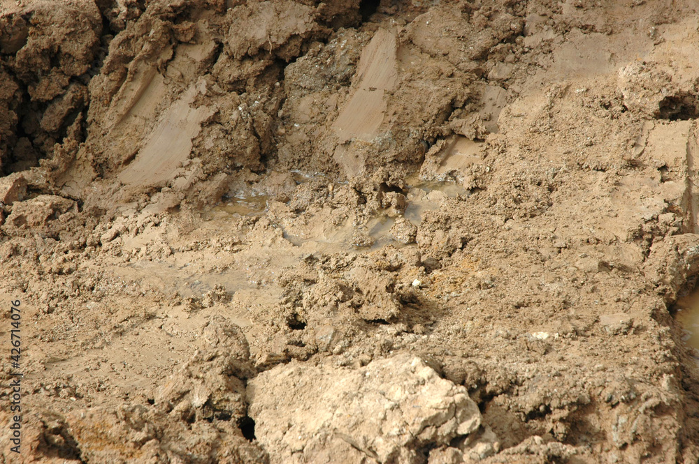 heaps of wet clay and puddles of water with traces of traffic heaps of wet clay and puddles of water with traces of traffic