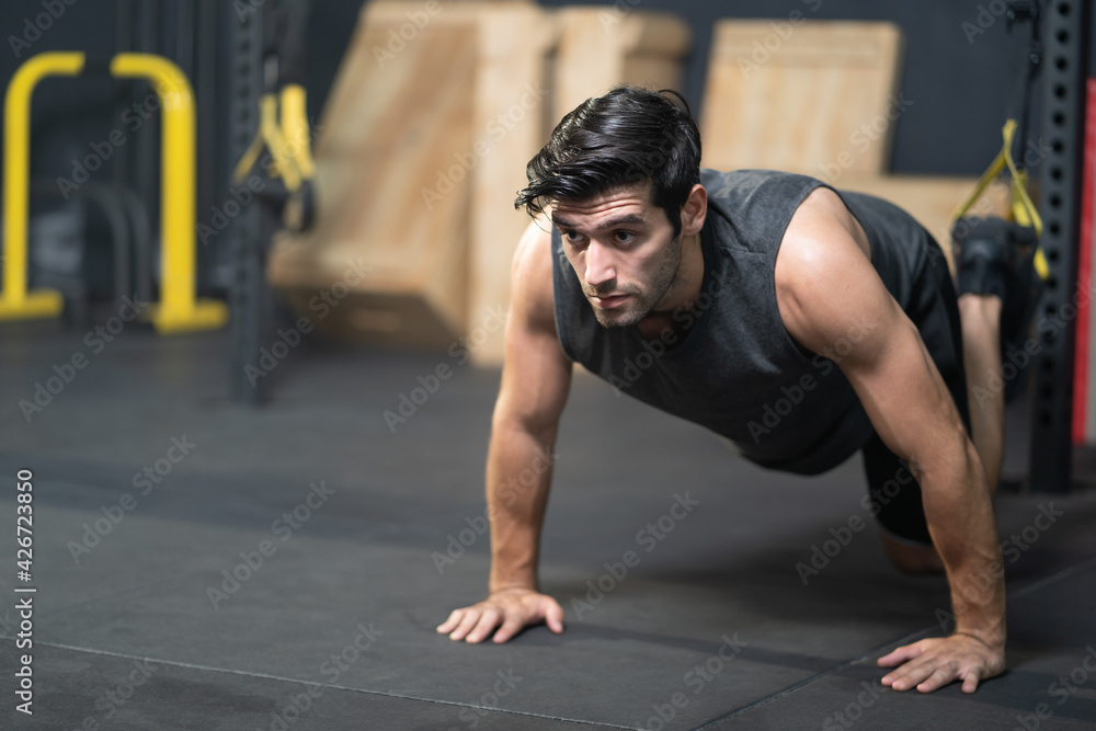 Handsome adult Caucasian men push up with trx robe to do crossfit exercise inside of fitness gym to workout for firm abs muscle and good body health. Handsome adult Caucasian men push up with trx robe to do crossfit exercise inside of fitness gym to workout for firm abs muscle and good body health.