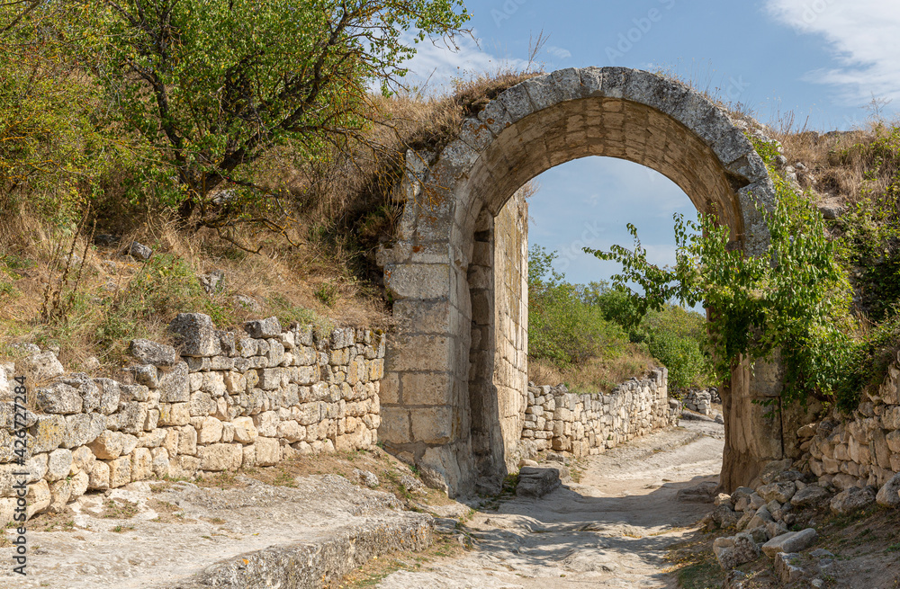 An ancient stone road with an arch .