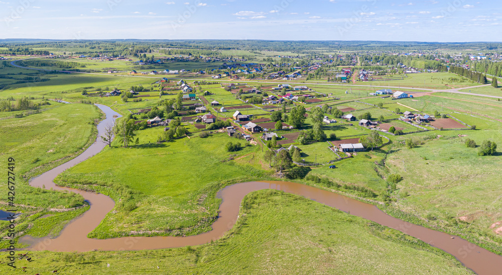 Aerial photo over a beautiful river, meadows and village.