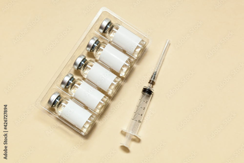 Syringe with a vaccine on a beige background Syringe with a vaccine on a beige background