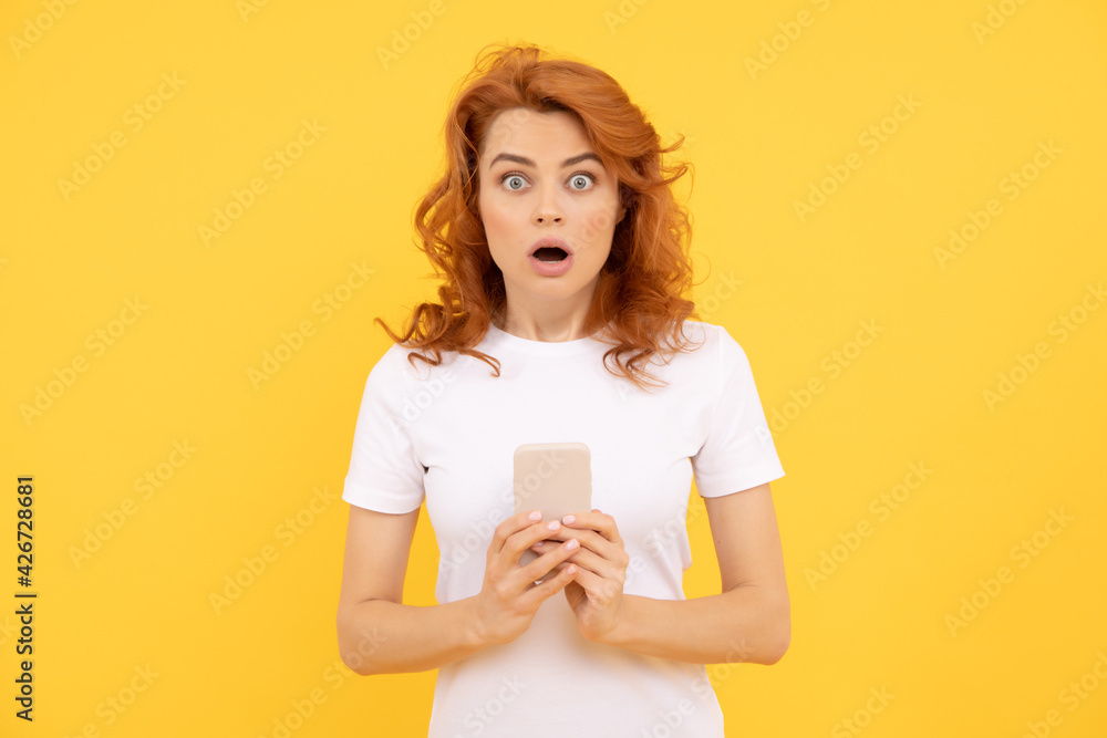 surprised woman chatting in smartphone or make online shopping on yellow background, surprise. surprised woman chatting in smartphone or make online shopping on yellow background, surprise.
