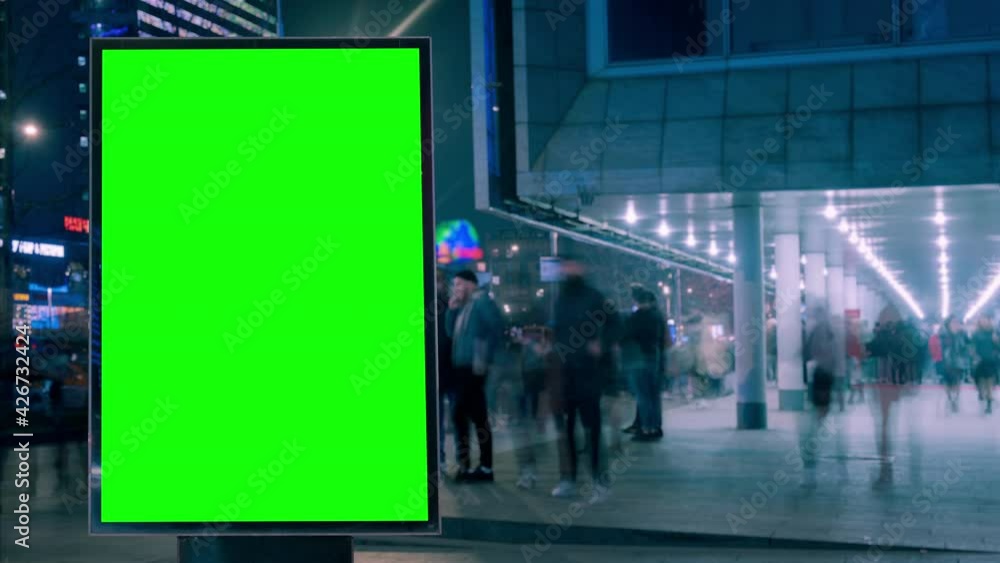 Modern billboard with green screen for advertising on a busy street with neon lights and people crowd, blank billboard, timelapse of traffic on busy highway, cyberpunk colors Modern billboard with green screen for advertising on a busy street with neon lights and people crowd, blank billboard, timelapse of traffic on busy highway, cyberpunk colors
