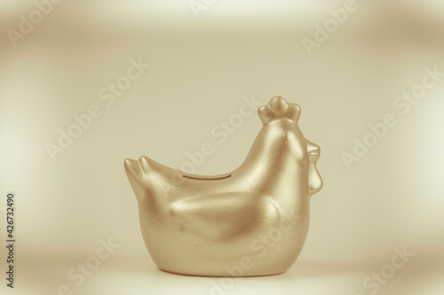 Golden chicken bank isolated on gold background ,saving money concept