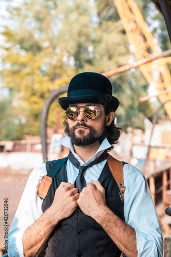 Steampunk. A hero on a river barge surrounded by steel mechanisms. A man with a weapon.