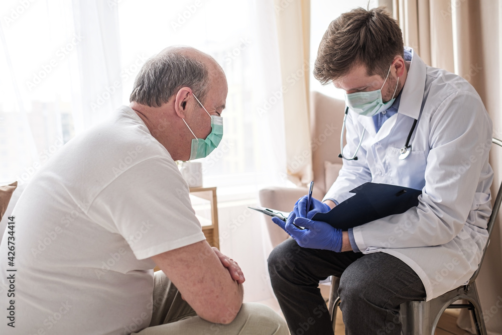 Fototapeta premium Doctor writing medical prescription to elderly man