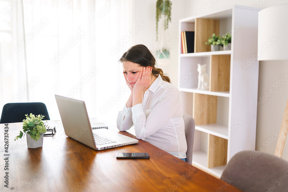 frustrated and sad woman working on laptop at home frustrated and sad woman working on laptop at home