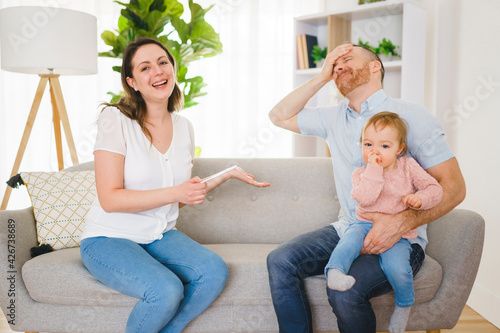 Sad Couple with pregnancy test at home interior with baby photo