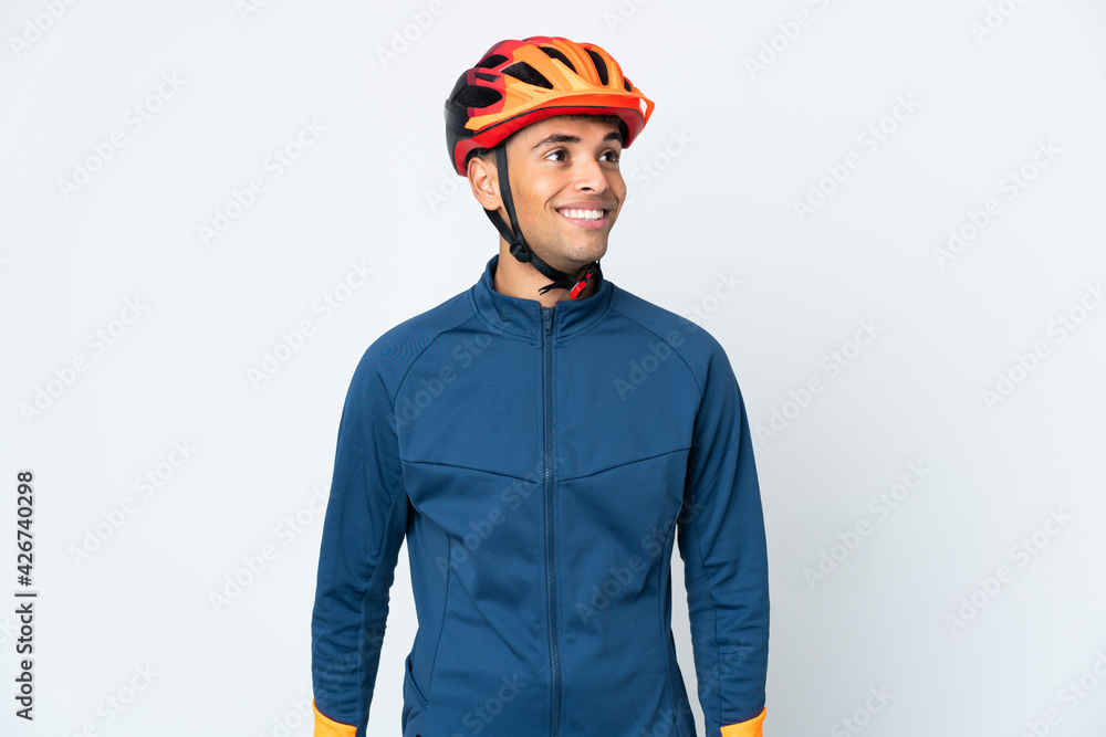 Fototapeta premium Young cyclist Brazilian man isolated on white background thinking an idea while looking up