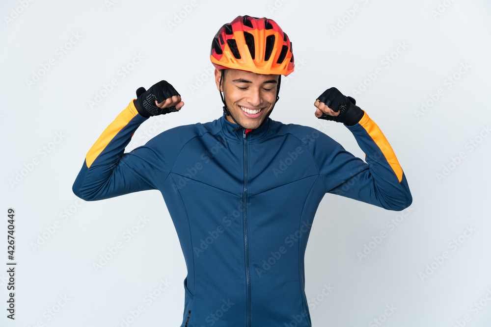 Young cyclist Brazilian man isolated on white background doing strong gesture - obrazy, fototapety, plakaty 