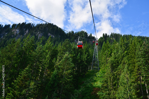 Beautiful landscape with pine trees and cable car up to Hahnenkamm ski run on Kitzbuhel, Tirol, Austria