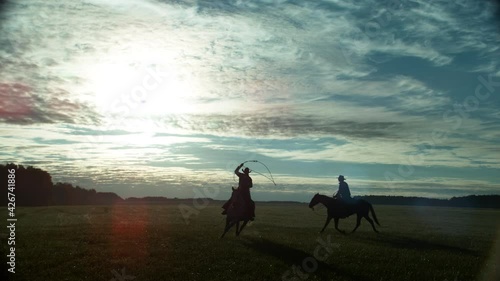 Horse Rider Guy Riding Stallion and Waving Lasso at Sunrise. Cowboy Gallop Ride Farm Animal and Exercise Skill on Farmland Meadow. Nature Grassland Field Countryside Land Scape Tracking Shot Slowmotio