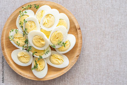 Boiled eggs on wooden plate over rustic background.