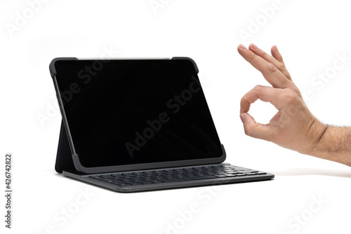 Tableta grande con teclado y una mano haciendo OK photo