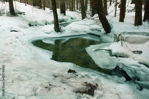 Small mountain river, covered by snow.  Czech nature. 
