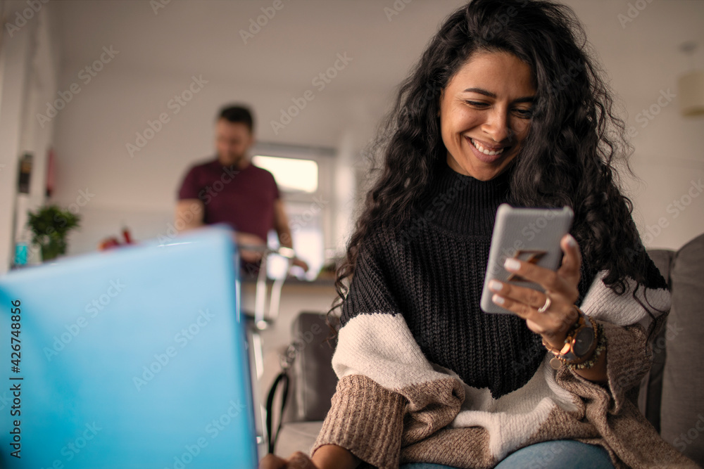 © Sam Edwards/Caia Image - Happy woman working from home with laptop and smart phone © Sam Edwards/Caia Image - Happy woman working from home with laptop and smart phone