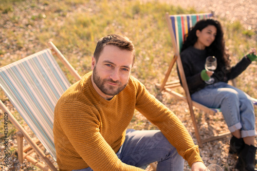 Portrait confident man relaxing in lawn chair by girlfriend