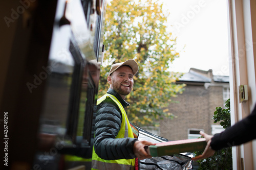Friendly delivery man delivering pizza at front door