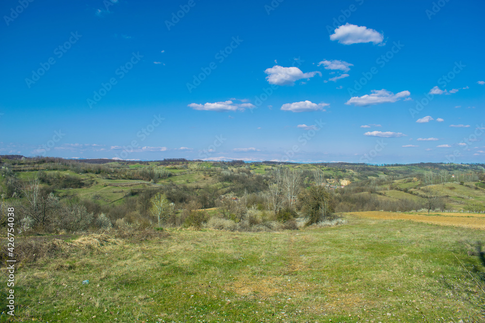 Fototapeta premium Green valleys and hills, blue sky. Arrival of Spring