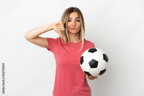 Young football player woman over isolated white wall showing thumb down with negative expression