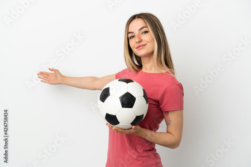 Young football player woman over isolated white wall extending hands to the side for inviting to come © luismolinero
