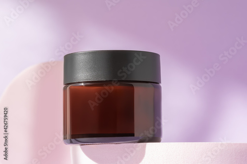 Organic face cream cosmetic mock up on podium, low angle view, copy space. Blank jar of luxury lotion in brown bottle standing on pedestal showcase. Beauty packaging mockup product presentation