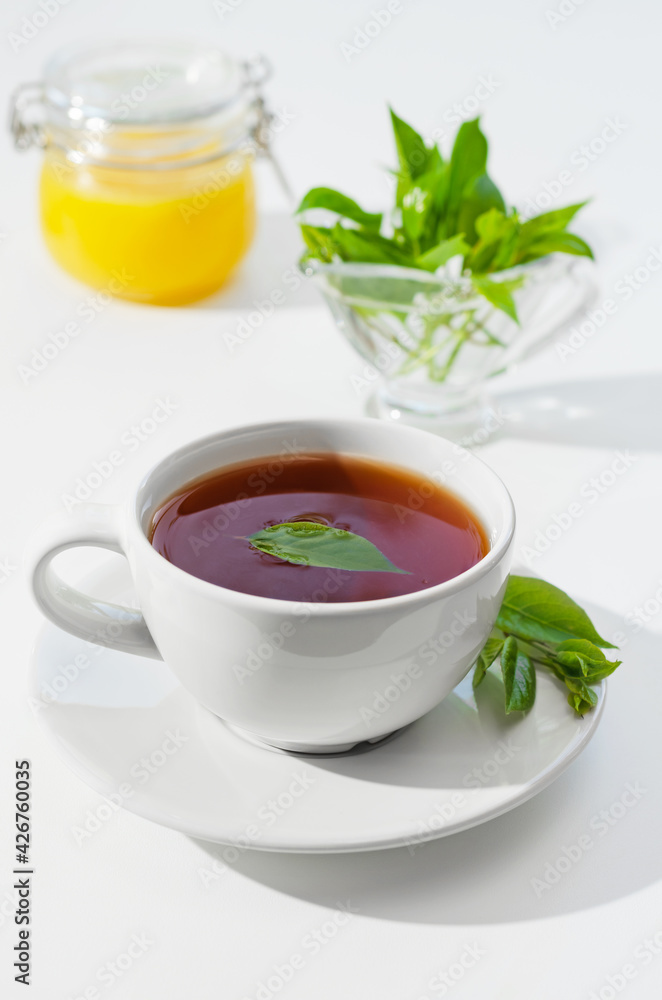 Cup of hot tea with lemongrass leaves and honey, on a white background. Shallow depth of field Cup of hot tea with lemongrass leaves and honey, on a white background. Shallow depth of field