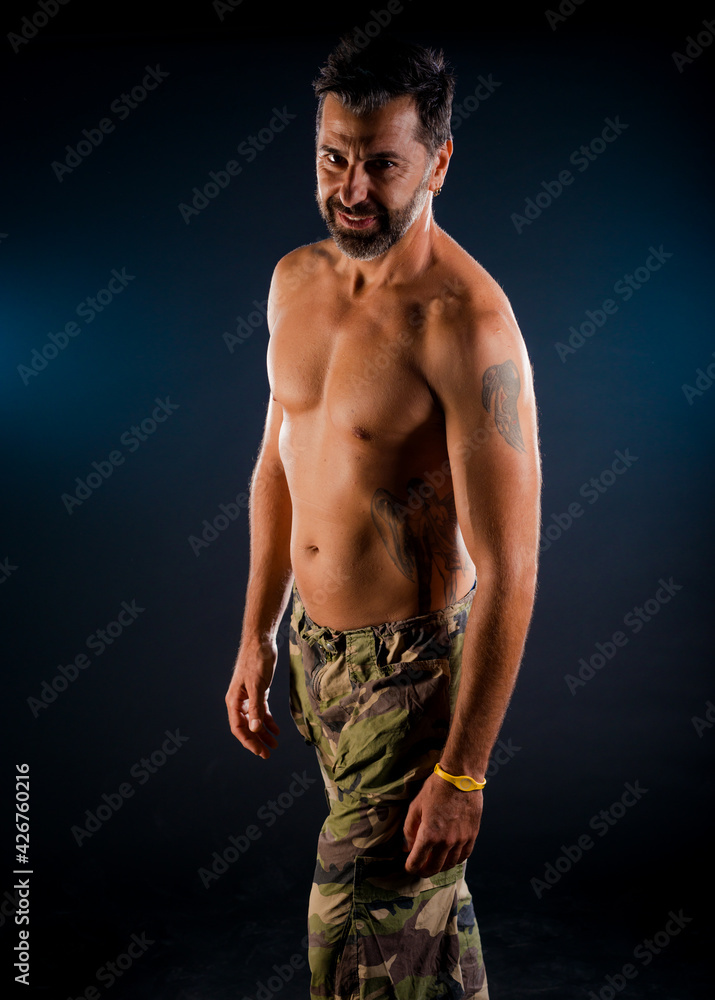 Fototapeta premium Healthy muscular young man on a dark background