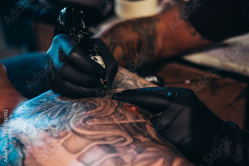 Tattoo artist hands creating a picture