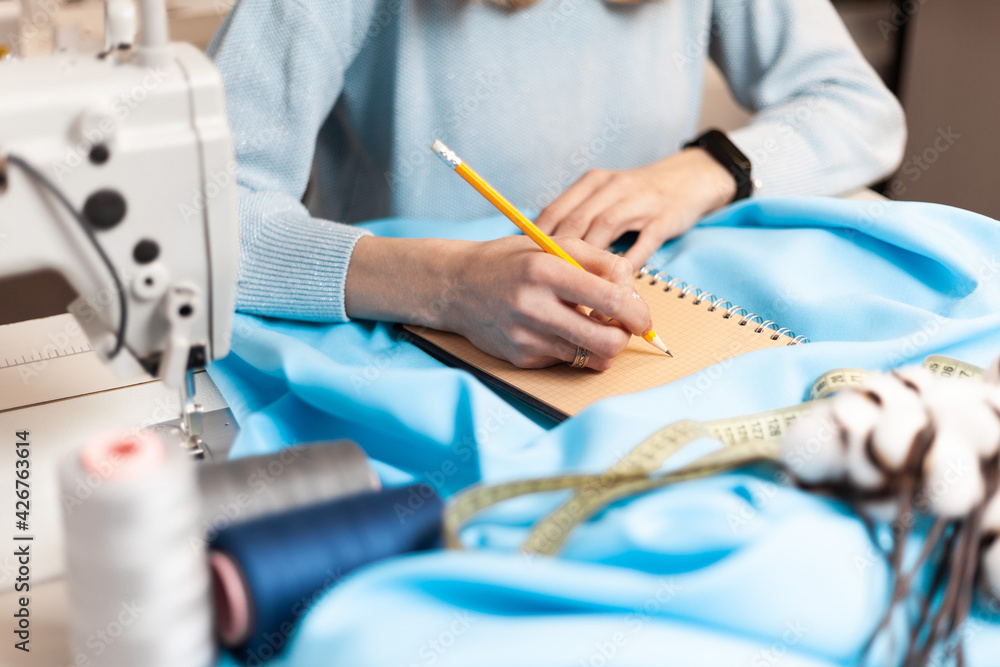 Fototapeta premium Draws clothing design. Workplace atelier with notepad. Tailoring order.