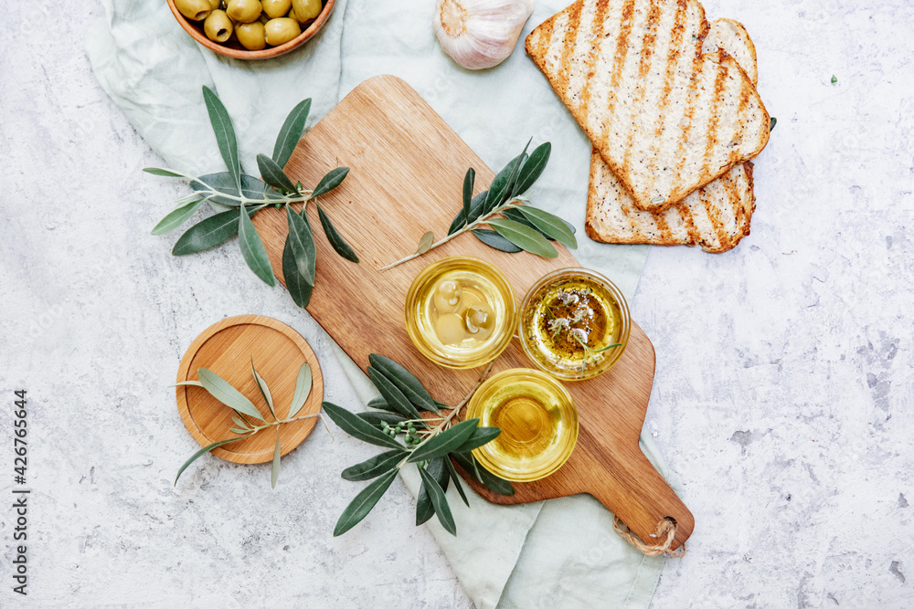 Olive Oil. Organic olive oil in bowl with green olives, herbs, spices and ciabatta bread on white background , banner, healthy mediterranean food concept... - obrazy, fototapety, plakaty 