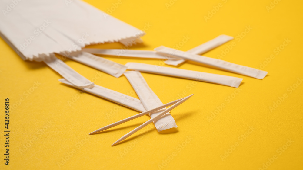 Scattered individual paper wrapped toothpicks. Packed wooden toothpicks. Individually wrapped mint wooden toothpicks