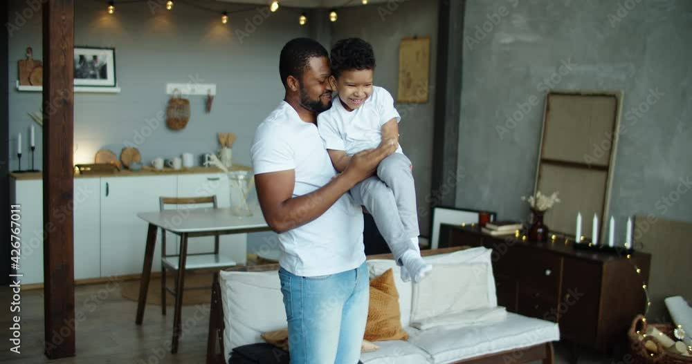 Happy african american father tickling laughing adorable son close up, family having fun at home, smiling dad holding hugging little boy, playing game, enjoying weekend. High quality 4k footage Happy african american father tickling laughing adorable son close up, family having fun at home, smiling dad holding hugging little boy, playing game, enjoying weekend. High quality 4k footage
