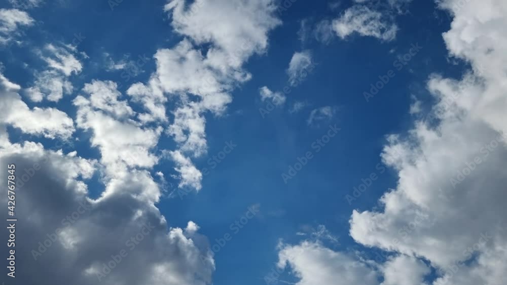 4k time lapse. Fluffy white clouds illuminated by the sun moving slowly across the blue sky. Weather theme. 4k time lapse. Fluffy white clouds illuminated by the sun moving slowly across the blue sky. Weather theme.