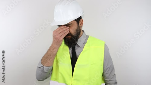 Architect wearing safety helmet and reflective jacket tired rubbing nose and eyes feeling fatigue and headache. Stress and frustration concept.
