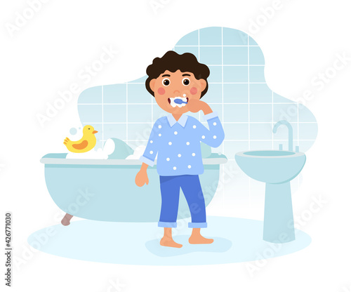 Happy little boy brushing teeth in the bathroom.