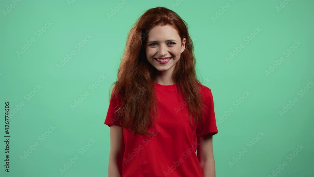 Portrait of woman laughs over green studio background. Positive young girl with red hair smiles to camera. Portrait of woman laughs over green studio background. Positive young girl with red hair smiles to camera.