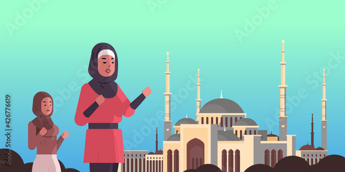 arab women coming to nabawi mosque building ramadan kareem holy month religion concept arabic prayers in traditional clothes muslim sityscape horizontal flat portrait