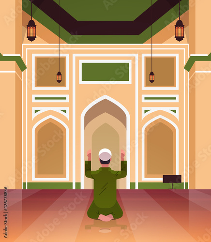 religious muslim man kneeling and praying inside mosque building ramadan kareem holy month religion concept rear view full length vertical