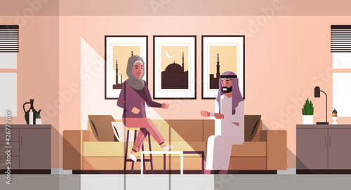 muslim couple celebrating ramadan kareem holy month living room interior arabic man woman in traditional clothes discussing during meting flat horizontal full length