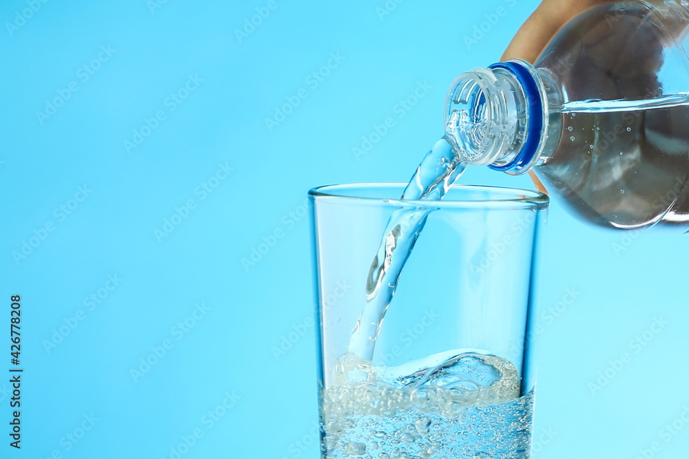 water is poured from a bottle into a glass close up. filling a glass with clean water from a bottle