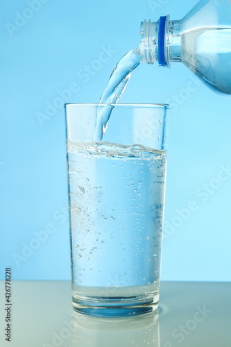 water is poured from a bottle into a glass close up. filling a glass with clean water from a bottle